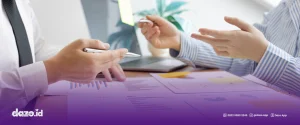 terdapat dua orang yang sedang berdiskusi di depan meja yang didalamnya berserakan kertas kertas. Mendiskusikan Memilih Aplikasi Order Management Sesuai Skala Bisnis