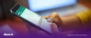 terdapat handphone dan jari seseorang berwarna biru muda yang sedang menggunakan Autoresponder WA