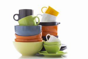 Terdapat beberapa pilihan produk peralatan rumah tangga yang terpampang seperti gelas berwarna hijau hitam putih dan kuning, serta terdapat tumpukan mangkuk berwarna hijau oren dan biru